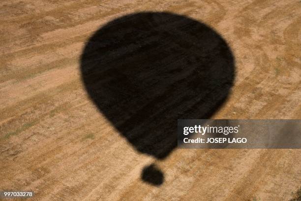 The shadow of a hot-air balloon is pictured during the 22th European Balloon Festival in Igualada, near Barcelona on July 12, 2018. - The European...