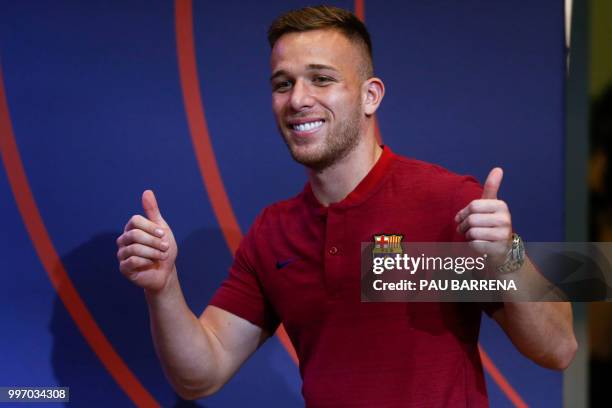 Barcelona's new player Brazilian midfielder Arthur Henrique Ramos de Oliveira Melo gives the thumbs up during a press conference at the Auditorium...