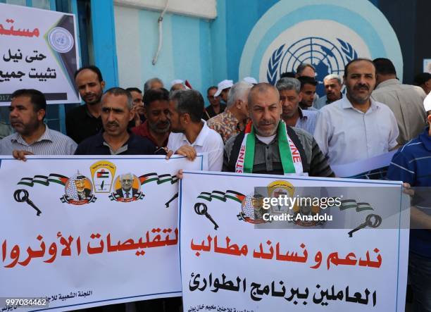 The United Nations Relief and Works Agency for Palestine Refugees in the Near East staff hold banners during a protest as they demand the protection...