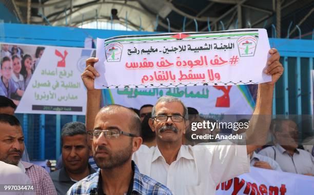 The United Nations Relief and Works Agency for Palestine Refugees in the Near East staff hold banners during a protest as they demand the protection...