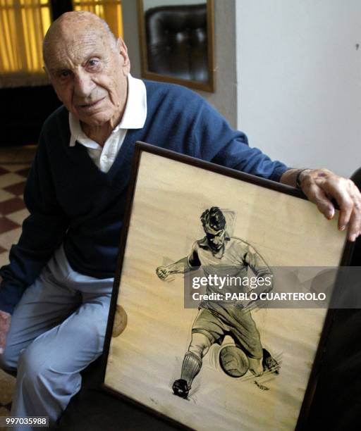 Argentinian ex soccer player, Francisco "Pancho" Varallo, poses with a drawing depicting himself on the time he played for Boca Juniros, at his house...