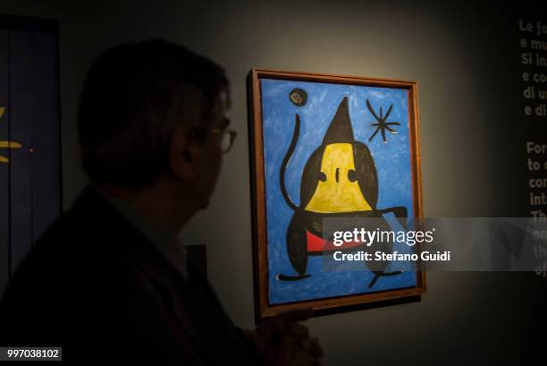 Man in the shadows looks at the painting during on exhibition of famous painter Joan Mirò at the Palazzo Chiablese.