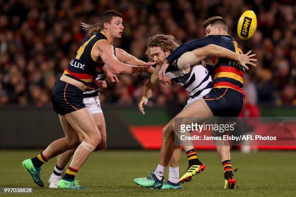 Cameron Guthrie of the Cats is tackled by Josh Jenkins and Bryce Gibbs of the Crows during the 2018 AFL round 17 match between the Adelaide Crows and...