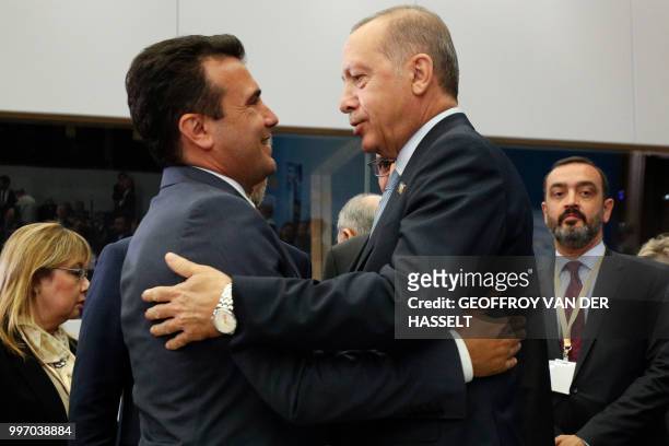 Macedonian Prime Minister Zoran Zaev embraces Turkey's President Recep Tayyip Erdogan during a meeting on the second day of the North Atlantic Treaty...