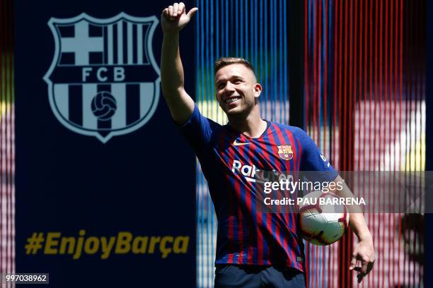 Barcelona's new player Brazilian midfielder Arthur Henrique Ramos de Oliveira Melo waves during his official presentation at the Camp Nou Stadium in...
