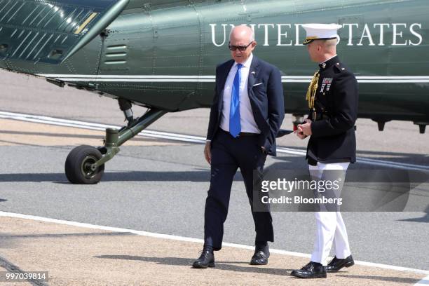 Woody Johnson, U.S. Ambassador to the United Kingdom, left, speaks to a military official as they wait the arrival of U.S. President Donald Trump at...