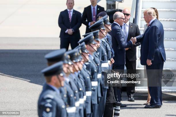 President Donald Trump, right, shakes hands with Woody Johnson, U.S. Ambassador to the United Kingdom, after arriving at London Stansted Airport in...