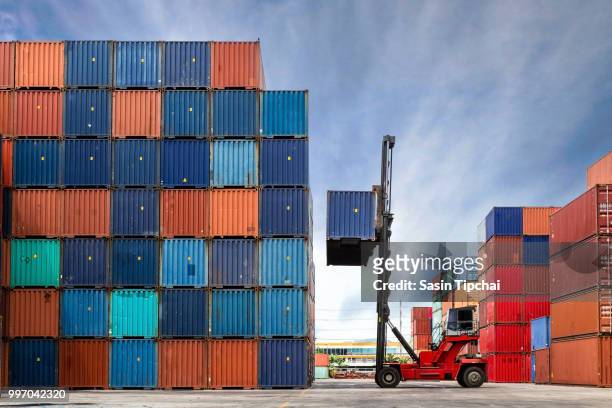crane lifting up container in yard - freight transportation stock-fotos und bilder