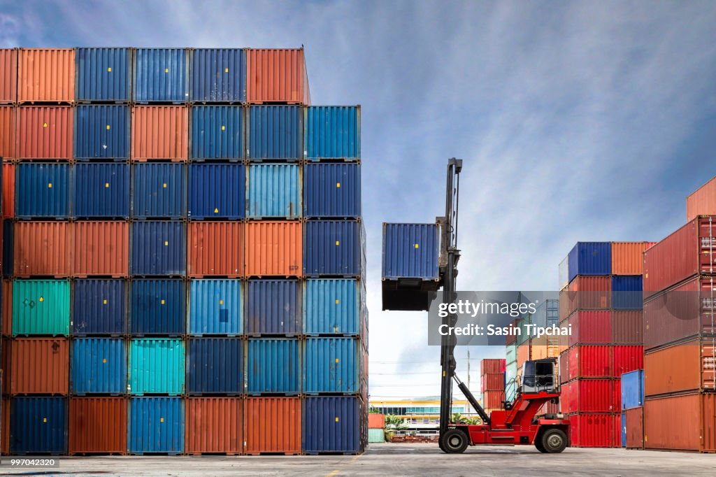 Crane lifting up container in yard