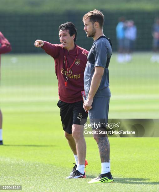 Arsenal Head Coach Unai Emery with Aaron Ramsey during a training session at London Colney on July 12, 2018 in St Albans, England.