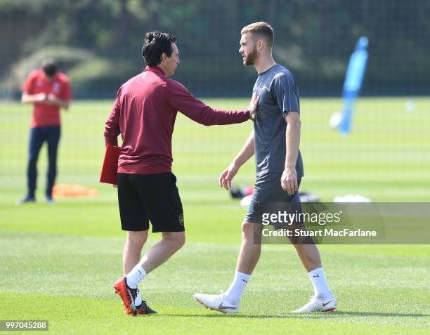 Arsenal Head Coach Unai Emery with Calum Chambers during a training session at London Colney on July 12, 2018 in St Albans, England.