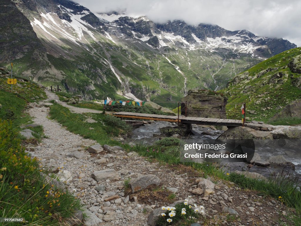 Multi-colored Prayer Flags on Small Wooden Bridge in Anzasca Valley