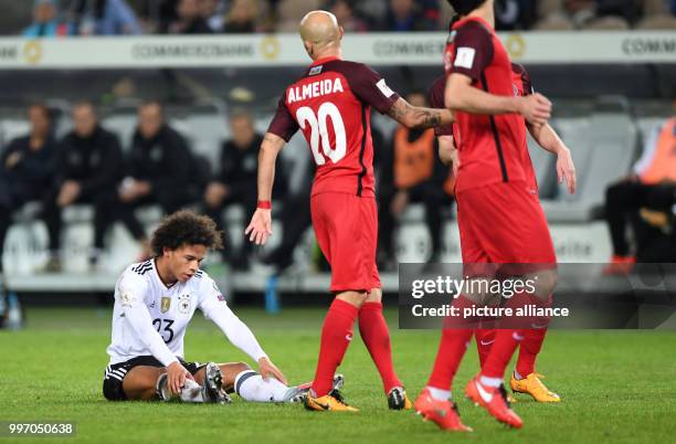 Germany's Leroy Sane sits on the green during the World Cup Group C quailification soccer match between Germany and Azerbaijan at the Fritz Walter...