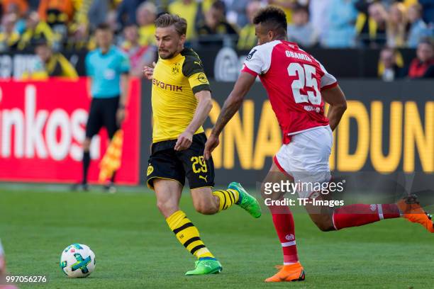 Marcel Schmelzer of Dortmund and Jean-Philippe Gbamin of Mainz battle for the ball during the Bundesliga match between Borussia Dortmund and 1. FSV...