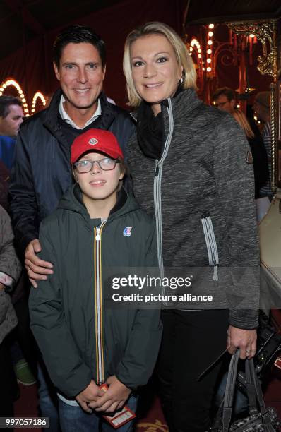 The former ski athlete Maria Hoefl-Riesch, her husband Marcus Hoefl and his son Luca smile and pose during the premiere gala of Circus Roncalli under...