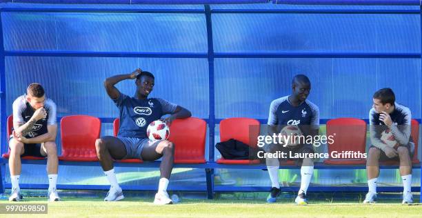 Lucas Hernandez, Paul Pogba, Ngolo Kante and Antoine Griezmann sit on the bench during a France trainig session on July 12, 2018 in Moscow, Russia.