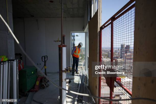 Worker inspects a unit during construction of the GWL Realty Advisors Livmore luxury apartment building in Toronto, Ontario, Canada, on Tuesday, July...