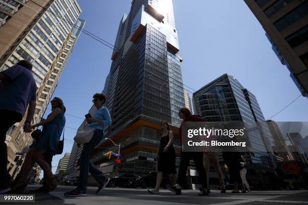 Pedestrians pass in front of the GWL Realty Advisors Livmore luxury apartment building stands under construction in Toronto, Ontario, Canada, on...