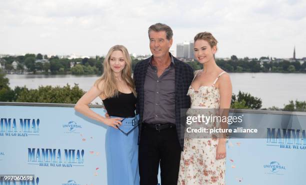 July 2018, Germany, Hamburg: American actress Amanda Seyfried , British actress Lily James and Irish actor Pierce Brosnan at the photocall of "Mamma...