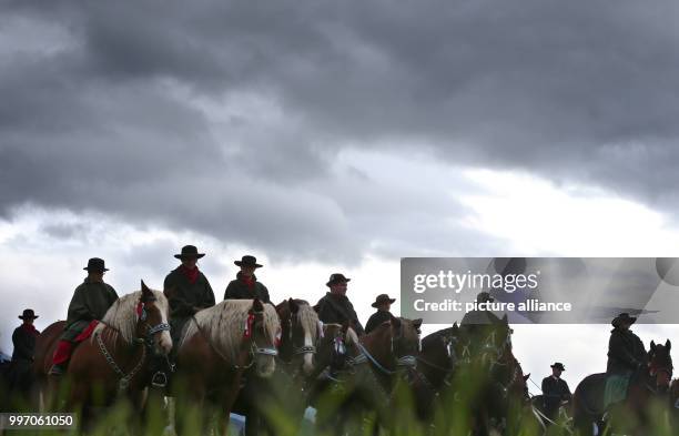 Men and women in traditional dress ride on festively adorned horses from the St. Coloman church near Schwangau, Germany, 8 October 2017. They are...