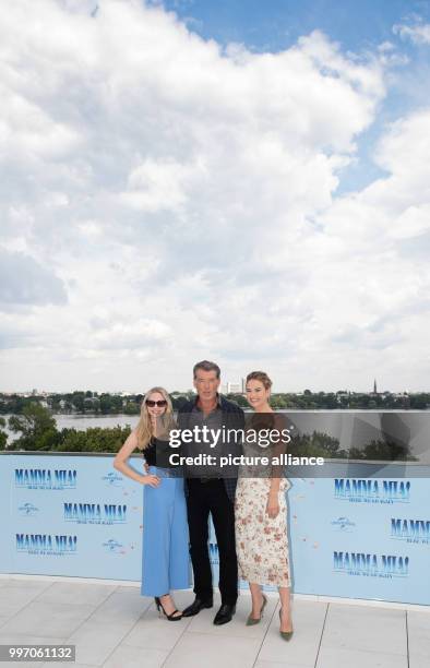 July 2018, Germany, Hamburg: American actress Amanda Seyfried , British actress Lily James and Irish actor Pierce Brosnan at the photocall of "Mamma...