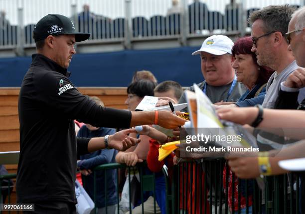 Rickie Fowler of USA signs autographs for fans at the 18th after finishing his round during the first day of the Aberdeen Standard Investments...
