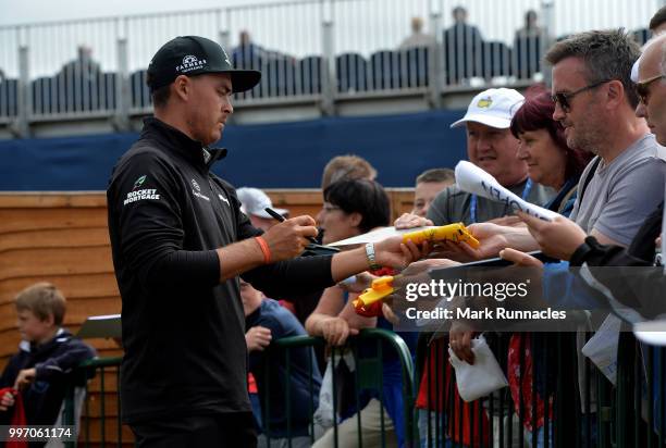 Rickie Fowler of USA signs autographs for fans at the 18th after finishing his round during the first day of the Aberdeen Standard Investments...