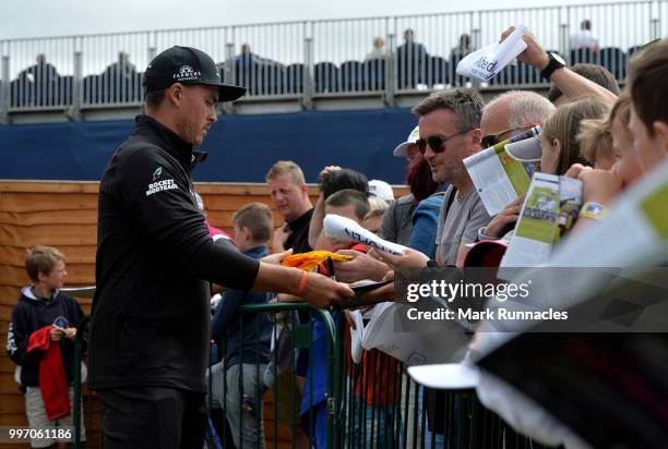 Rickie Fowler of USA signs autographs for fans at the 18th after finishing his round during the first day of the Aberdeen Standard Investments...