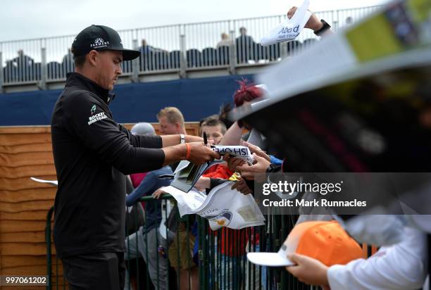 Rickie Fowler of USA signs autographs for fans at the 18th after finishing his round during the first day of the Aberdeen Standard Investments...