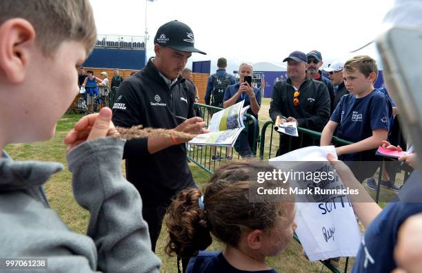 Rickie Fowler of USA signs autographs for fans at the 18th after finishing his round during the first day of the Aberdeen Standard Investments...