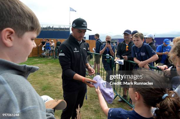 Rickie Fowler of USA signs autographs for fans at the 18th after finishing his round during the first day of the Aberdeen Standard Investments...