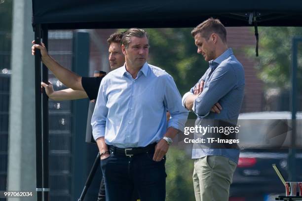 Sporting director Michael Zorc of Dortmund speaks with Head of the Licensing Player Department Sebastian Kehl of Dortmund during a training session...