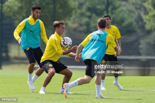 Nuri Sahin of Dortmund and Mario Goetze of Dortmund battle for the ball during a training session at BVB training center on July 12, 2018 in...
