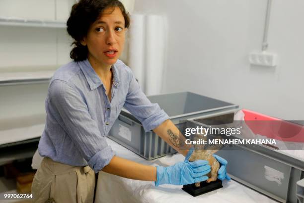 Curator Morag Wilhelm holds an artifact which belonged to Sigmund Freud at the Israel Museum in Jerusalem on July 12, 2018. - A new exhibition in...