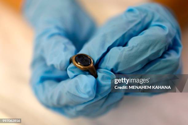Curator Morag Wilhelm holds a signet ring that had been given by Sigmund Freud to close students, at the Israel Museum in Jerusalem on July 12, 2018....