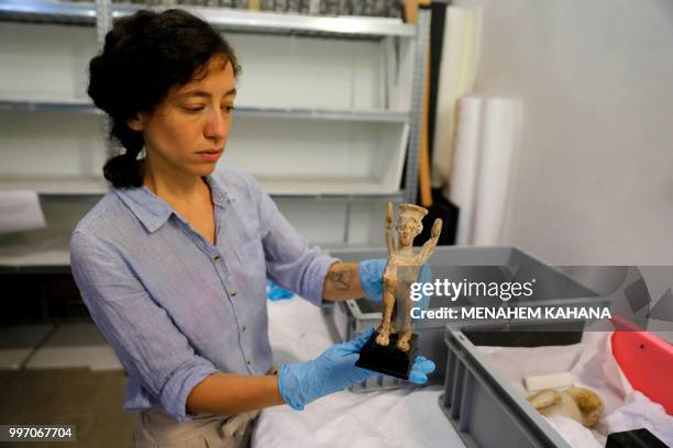 Curator Morag Wilhelm holds an artifact which belonged to Sigmund Freud at the Israel Museum in Jerusalem on July 12, 2018. - A new exhibition in...