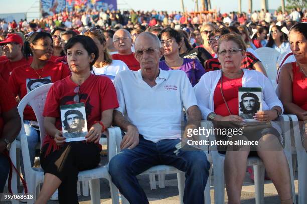 People hold up pictures of revolutionist Che Guevara in Santa Clara, Cuba, 08 October 2017. Cuba honors the 50. Anniversary of the death of its...
