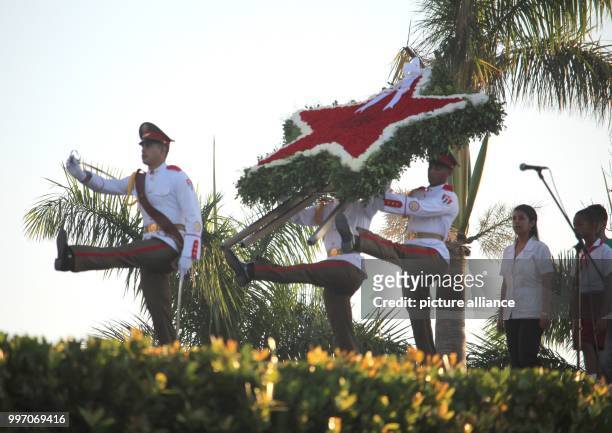 Soldiers carry a floral wreath during a ceremony to honour Argentine Marxist revolutionary Ernesto Che Guevara, on the 50th anniversary of his death...