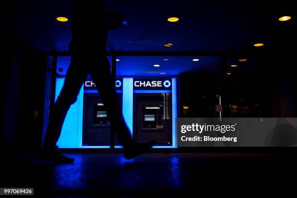 Pedestrian passes in front of JPMorgan Chase & Co. Automatic teller machines at night in Chicago, Illinois, U.S., on Tuesday, July 10, 2017. JPMorgan...