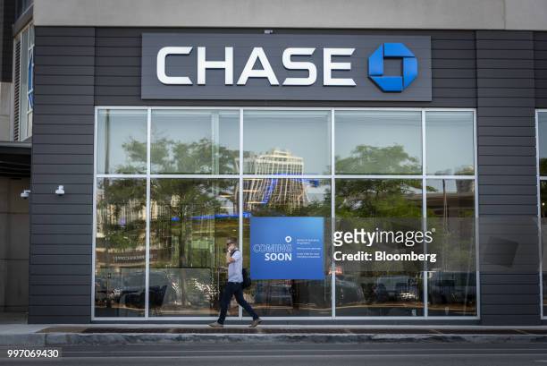 Pedestrian speaks on a mobile device while passing in front of a JPMorgan Chase & Co. Bank branch in Chicago, Illinois, U.S., on Tuesday, July 10,...