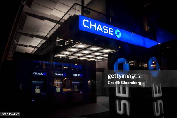 JPMorgan Chase & Co. Signage is illuminated at night at a bank branch in Chicago, Illinois, U.S., on Tuesday, July 10, 2017. JPMorgan Chase & Co. Is...
