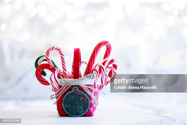candy canes in a basket on christmas background - christmas basket stock pictures, royalty-free photos & images