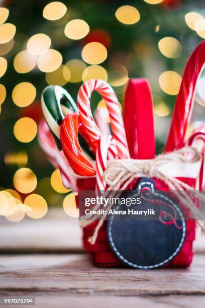 candy canes in a basket on christmas background - christmas basket stock pictures, royalty-free photos & images