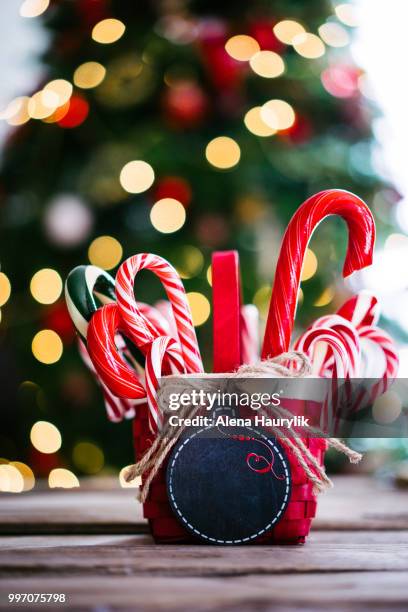 candy canes in a basket on christmas background - christmas basket stock pictures, royalty-free photos & images