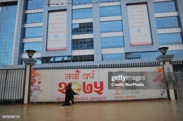 Man crossing through flood water overflowed from River affected due to incessant rainfall at Thimi, Bhaktapur, Nepal on Thursday, July 12, 2018....