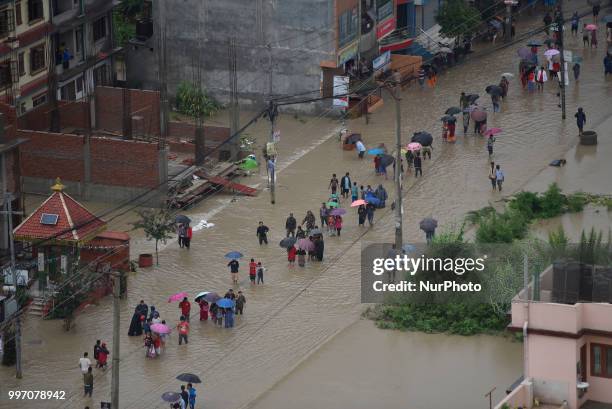 Nepalese people crossing through flood water overflowed from River affected due to incessant rainfall at Thimi, Bhaktapur, Nepal on Thursday, July...