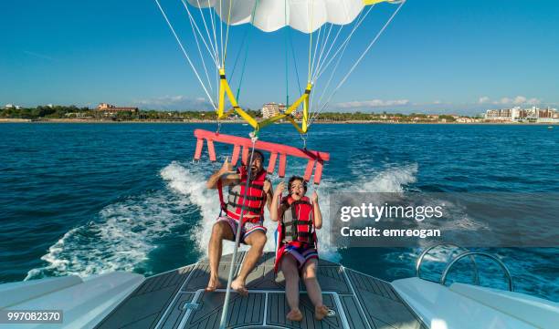 lovely couple during parasailing - parasailing imagens e fotografias de stock