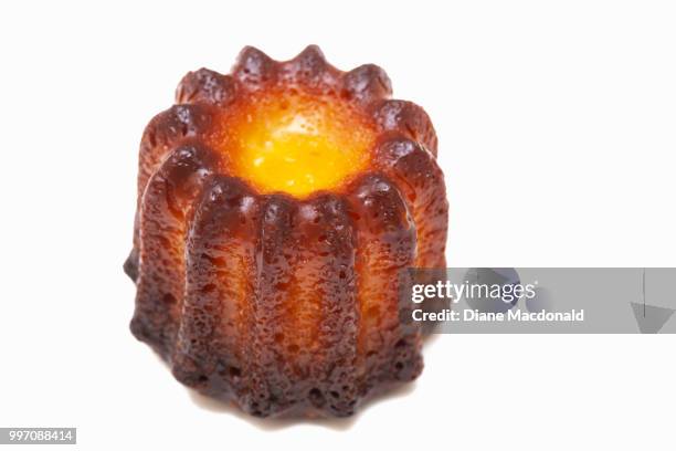 a french canelé de bordeaux on a white background - canele stockfoto's en -beelden