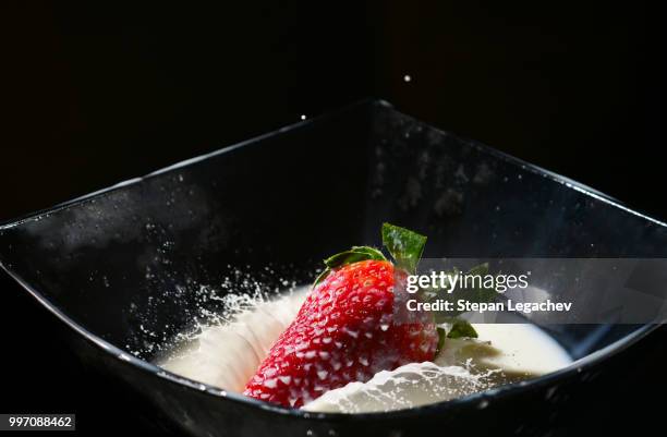 ripe strawberry falling in a milk with splash - strawberry falling stock-fotos und bilder