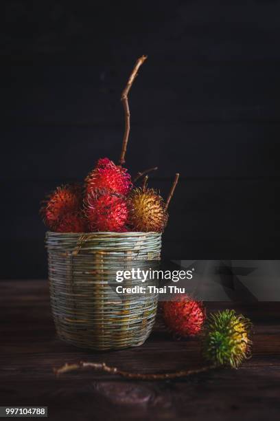 a basket of rambutans. - rambutan stock pictures, royalty-free photos & images